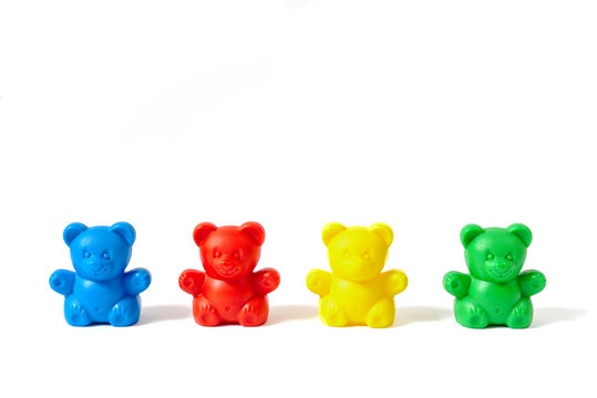 Blue, red, yellow and green plastic toy bears isolated on white background