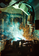 Worker, welding in a car factory with sparks, manufacturing, industry
