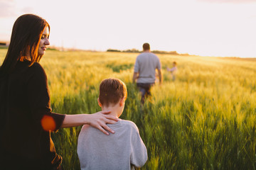 Mother and son walking away through the field