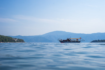 Yacht against the backdrop of the mountains. Pleasure boat moored in the middle of the sea