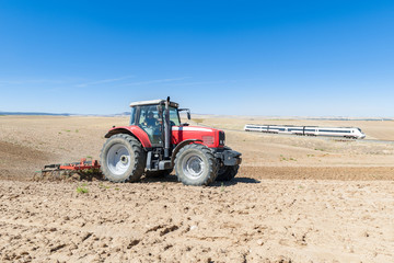 Obraz premium agricultural machinery in the foreground carrying out work in the field.