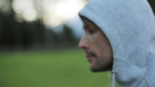 Man face head jogging close up slow motion outdoors green park background shallow macro. Sportsman in 30s runs in morning nature thinking dreaming making plans work future conscious look freedom eyes