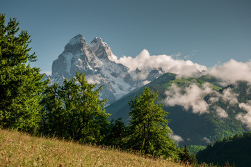 Obraz premium View from the valley to a very high beautiful rocky peak