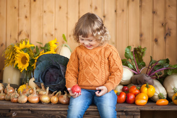 Fototapeta premium Adorable smiling toddler farmer with autumn harvest