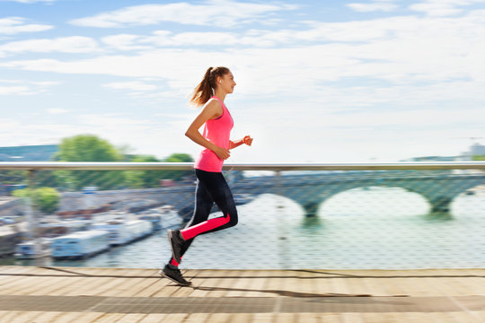 Woman running across bridge during cardio exercise