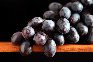 Black grape white water drops on the black background