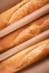 Crispy French loaves from bakery on wrapping paper