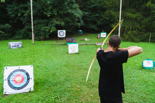 Man practicing archery in school