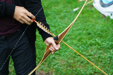 Crop man practicing archery in school