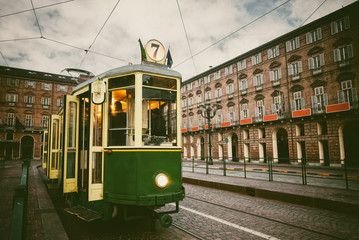 Vintage looking image of an historical tram waiting for passengers in Piazza Castello, main square of Turin (Italy)