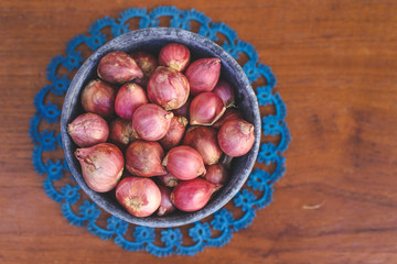 Shallot in a pot on wooden background with copy space