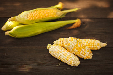 Fresh corn on cobs on rustic wooden table