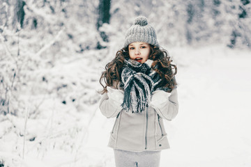Fototapeta na wymiar Portrait of cute little girl in winter forest.
