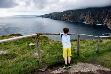 Fototapeta na wymiar Boy looking out over Slieve League Cliffs, County Donegal, Ireland