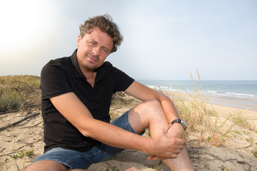 Outdoor portrait handsome man posing outdoor in in summer sun light