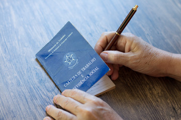 Hand signing brazilian work document on the table