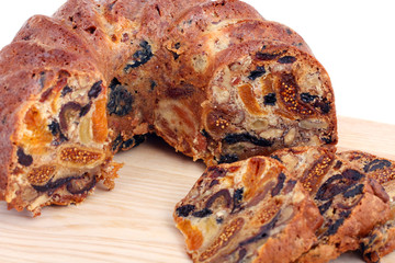 isolated traditional christmas stollen cake, sweet german bread, with dried fruits on wooden background