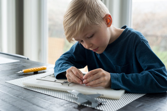 Little boy putting together model airplane