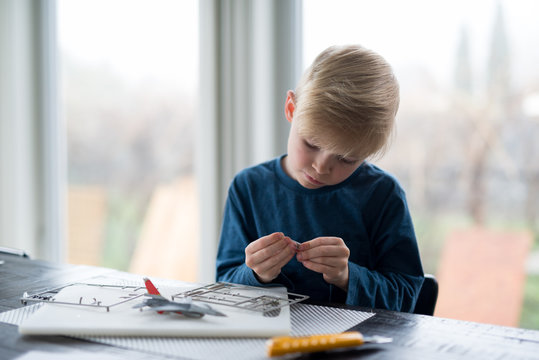 Little boy building model airplane