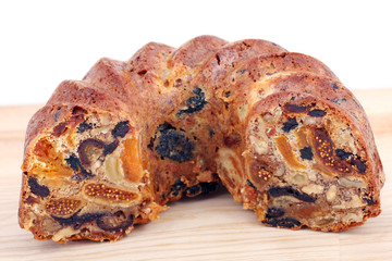 isolated traditional christmas stollen cake, sweet german bread, with dried fruits on wooden background