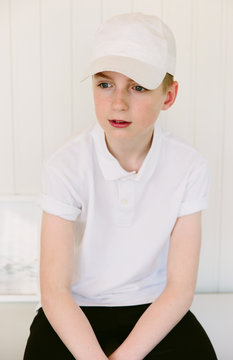 Teenage Boy Wearing A White Baseball Cap And Polo Shirt.