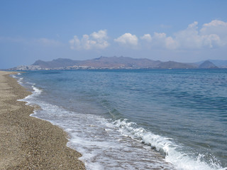 a deserted beach after a storm against the backdrop of the Turkish mountains, Kos Island, Greece   ...