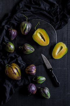 Pear-melons on a black wooden table