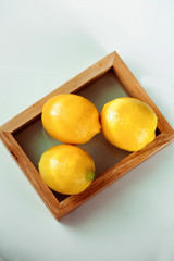 Fresh lemons in a wood basket on the White ground. Macro style