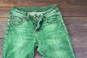 green Jeans on wooden texture background