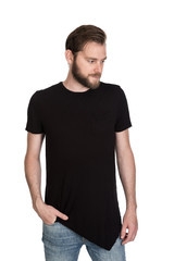 Obraz premium Mature staring man with beard wearing a black t-shirt standing against a white background looking at camera.