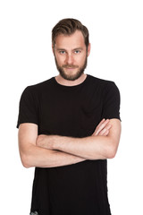 Mature staring man with beard wearing a black t-shirt standing against a white background looking at camera.