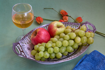 Glasses of wine and grapes on yellow background
