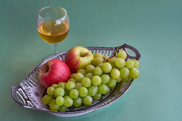 Glasses of wine and grapes on yellow background