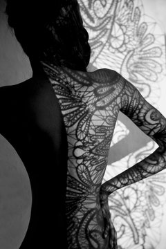 Lacy textured shadow on a black woman's back