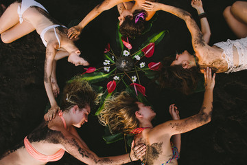 Spiritual women circle group on the beach doing feminine empowering workshop