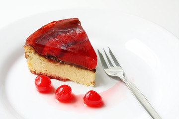 isolated on white served slice of fresh baked delicious cherry cheese cake with cherry topping