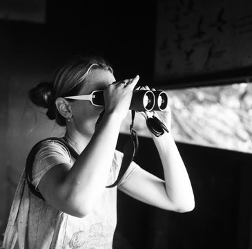 Bird watcher woman looking through binoculars