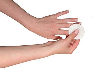 Female hands are washing off the nail polish with a cotton disc, isolated on a white background