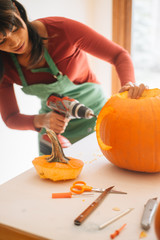 Woman carving halloween jack-o-lantern-pumpkin