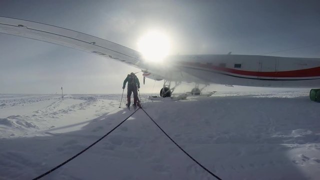 A tracking shot of a trekker that went through under a plane's wing.