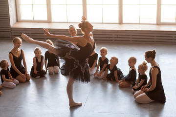 Little girls of the ballerina, European and Asian nationalities, black dresses and tulle pantyhose are shaken as the ballerina of the prima theater dances in the form of a black swan before the ballet