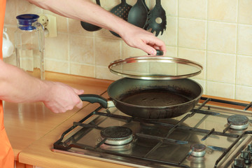 Closeup of human hand with frying fry pan.