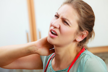 Overworked woman suffering from neck pain.