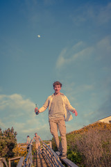 Young man walking on some railings, holding a Coca Cola bottle 