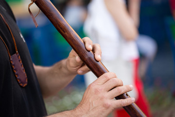 the man is playing on a wooden pipe