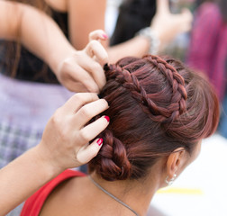 Naklejka premium the stylist weaves the female braids on the head