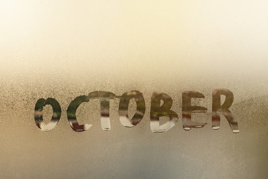 word oktober on wet glass window