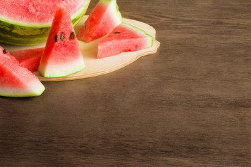 Slices of watermelon. Sweet, juicy treats on the wooden table. Healthy eating and lifestyle. Rustic atmosphere. Food concept.