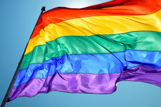 Rainbow flag on clear sky symbol of tolerance and acceptance