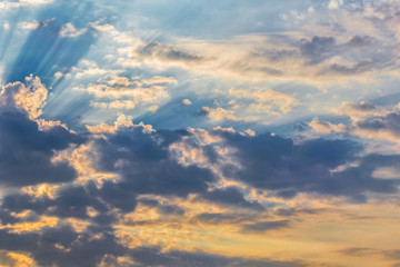 Fototapeta premium rays of the sun make their way through dramatic clouds, sunset and sunrise